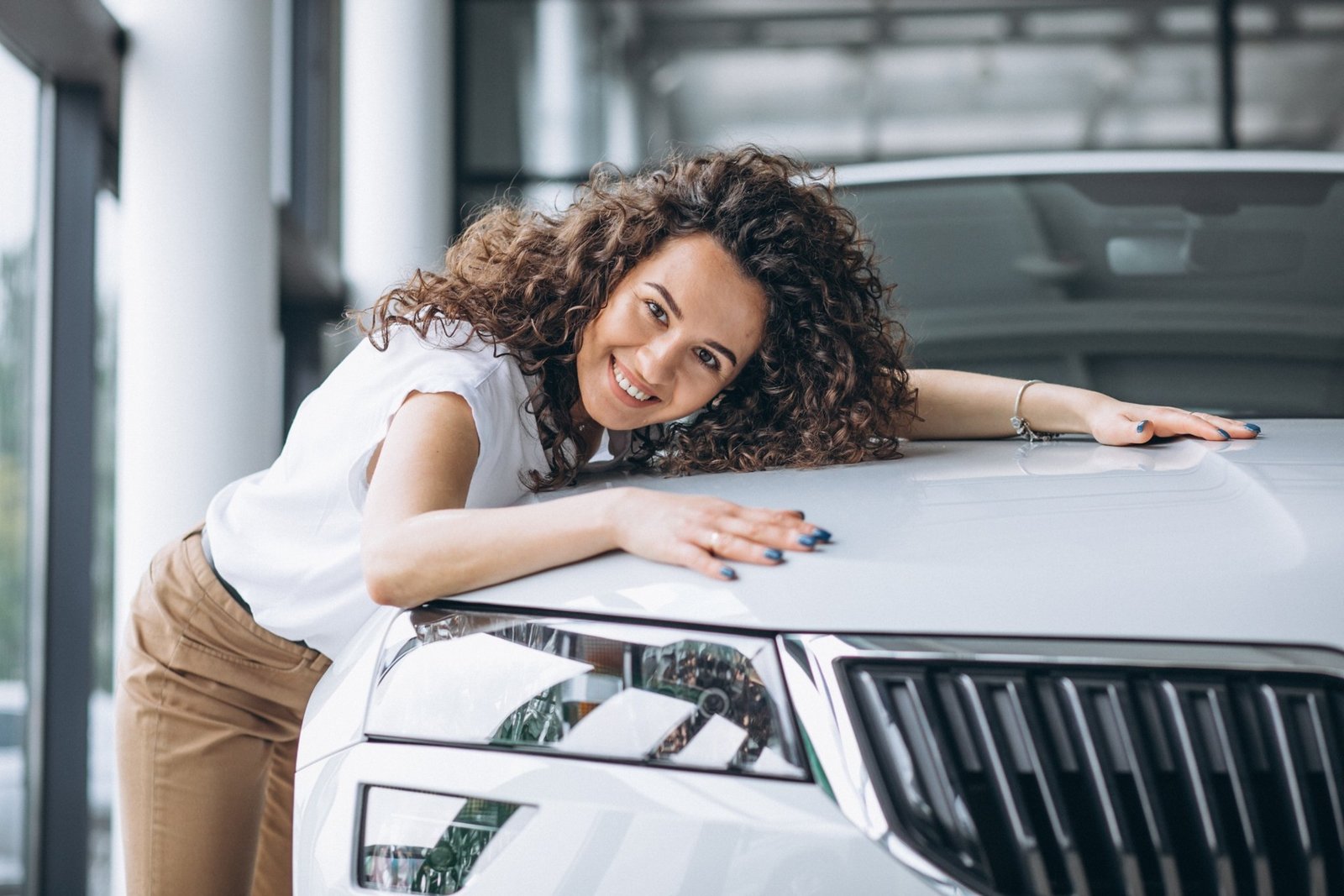 A woman smiling beside her car